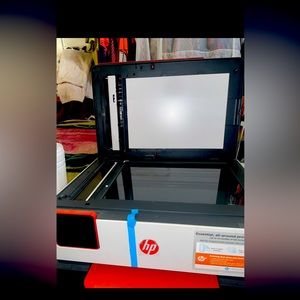 Red and white HP Printer . It’s brand new comes with paper and everything .